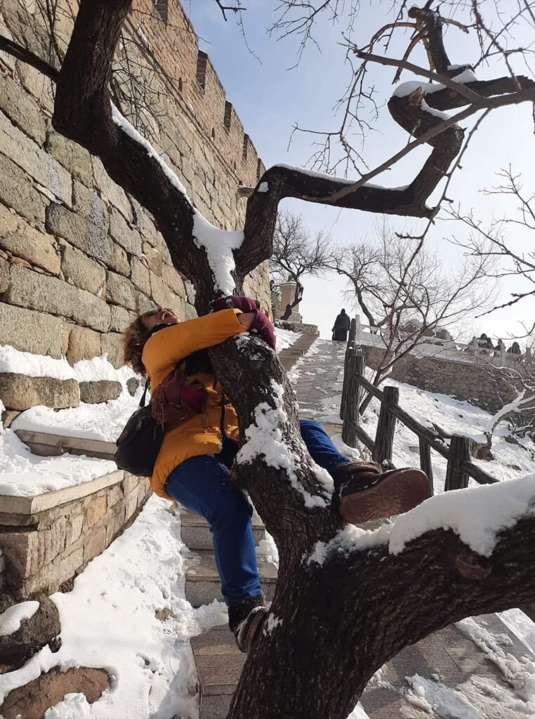 emocionanda subindo em uma arvore na Muralha da China em dez/19