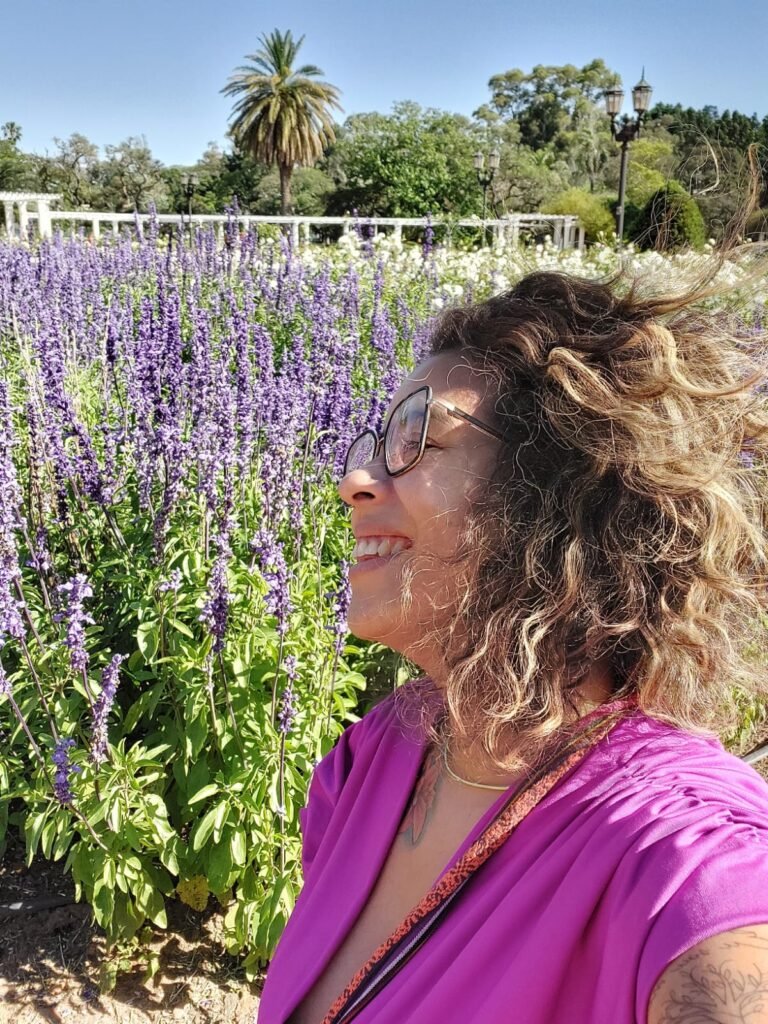 emocionanda com cabelos ao vento em frente as lavandas no Parque El Rosendal em Buenos Aires
